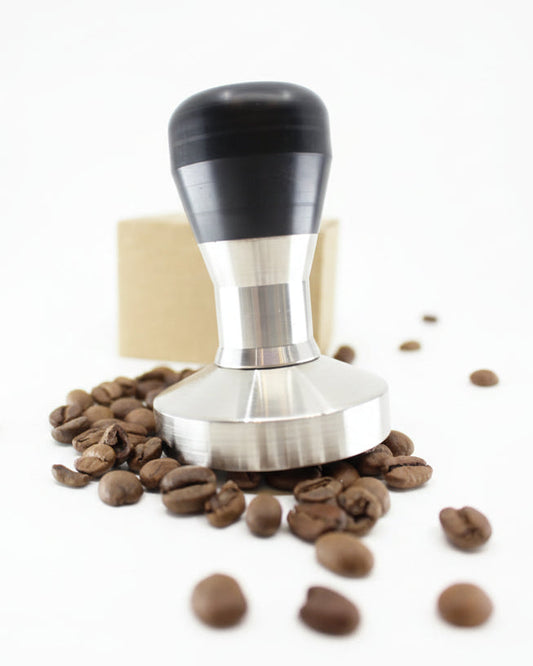 Coffee tamp with coffee beans on a white background